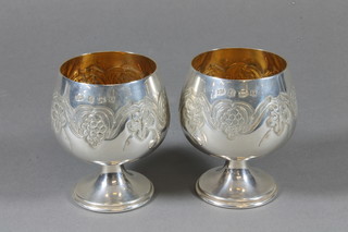 A pair of embossed silver goblets with parcel gilt interiors, Birmingham 1972, 7 ozs