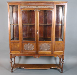 A late Victorian mahogany display cabinet in the Sheraton style, having fluted cornice above a pair of hairbell carved doors with  potboard below, raised on tapered legs 67"h x 53"w