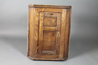 A mid 18th Century oak hanging corner cupboard, with moulded  cornice above a fielded cupboard door enclosing 2 shaped shelves  36.5"h x 29"w x 15"d