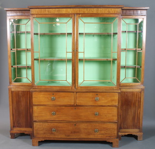A late George III mahogany breakfront bookcase having reed moulded cornice above 4 astragal bar glazed doors enclosing  shelves, above 2 short and 2 graduated long drawers flanked by  cupboard doors, raised on shaped plinth base 77"h x 81"w x 20"d