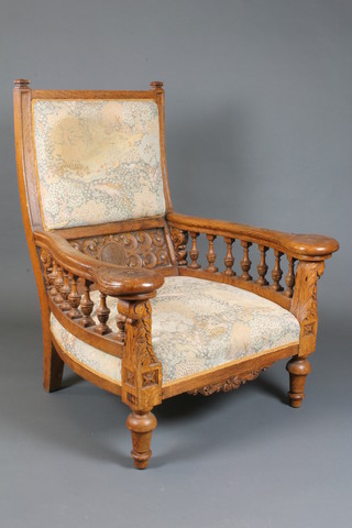 A pair of Victorian carved oak library chairs with upholstered seats and backs, raised on bulbous supports