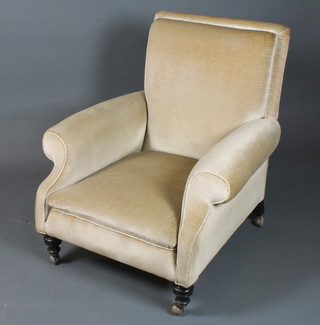 A late Victorian mahogany framed open arm chair with gold  Dralon upholstery, raised on ring turned tapered legs and casters