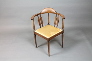 An Edwardian Sheraton revival mahogany corner elbow chair  with patterae cresting rail, raised on turned tapered legs, pad feet