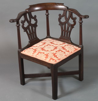 A George III mahogany smoker's bow corner chair having  scrolled cresting rail, pierced splats, raised on square chamfered  legs united by an X stretcher