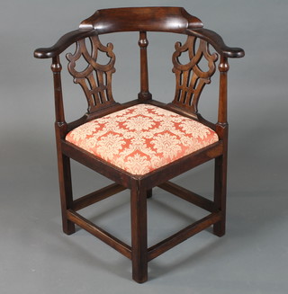 A George III mahogany smoker's bow corner chair with scroll cresting rail, shaped and pierced splats above a stuff over seat,  raised on square chamfered legs united by stretchers