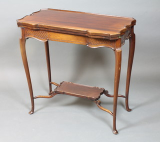 A 1920's mahogany card table in the French taste, the hinged top enclosing a baise lined interior raised on cabriole legs united by a  platform stretcher, pad feet, 29.5"h x 31"w x 31"d