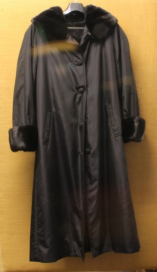 A lady's full length black "silk finished", fur lined and trimmed coat