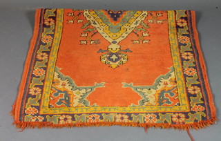 An orange coloured Afghan rug with centre medallion 62" x 36"