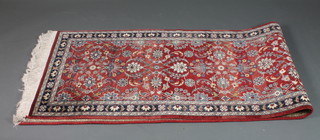 A 20th Century Persian red ground and floral patterned runner  125" x 29.5"