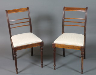 A pair of late George III mahogany dining chairs, satinwood crossbanded, fitted drop in seats on turned legs