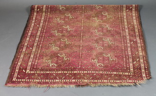 A red ground Afghan rug with 18 stylised octagons to the centre 84" x 51", worn