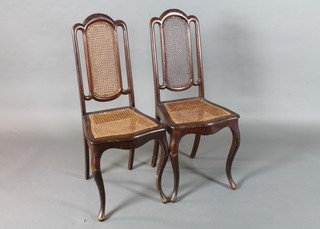 A pair of late 19th Century French walnut caned parlour chairs, raised on square cabriole legs