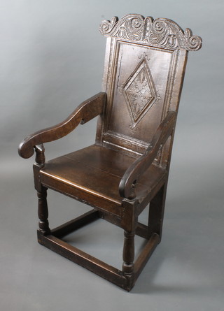 A 17th Century oak Wainscot elbow chair, having foliate and scroll carved cresting rail, the panelled back centred with a  foliate lozenge, shaped arms above solid seat, raised on turned  under frame  ILLUSTRATED