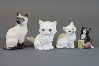 A Royal Doulton figure of a seated black kitten, do. white kitten,  Siamese cat and a Goebel figure of a white seated cat