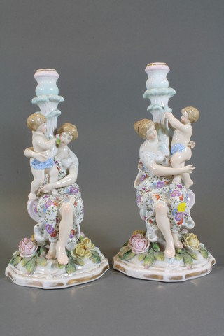 A pair of 19th Century Continental porcelain candlesticks  supported by figures of mother and child 13"