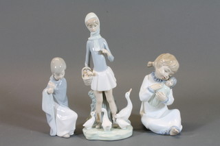 A Lladro figure of a standing girl with geese in basket, hand f,  base marked N29 9", do. seated girl with shawl, marked D28 8"  and a Nao figure of a girl with doll 6"
