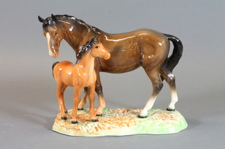 A Beswick figure of a standing bay mare and foal, raised on an  oval base 8"