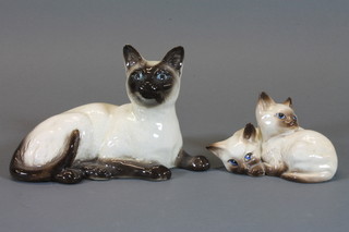 A Beswick Siamese cat, base marked 1559 6" and a group of  Siamese curled kittens, base marked 1296 4"