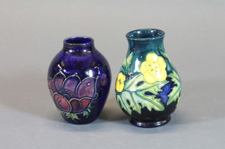 A Moorcroft green glazed club shaped vase decorated anemone  and buttercup, base impressed Moorcroft 4", designed by Sally  Tuffin