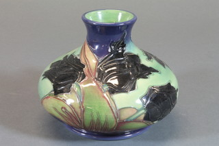 A Moorcroft circular green glazed vase decorated black tulips, the base incised a lozenge mark 5", designed by Sally Tuffin   ILLUSTRATED