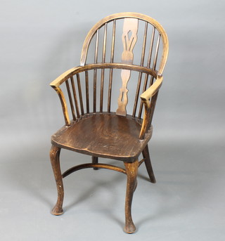 A George IV ash, beechwood and elm high back Windsor chair, having pierced and shaped splat above a saddle seat, raised on  cabriole legs united by a crinoline stretcher