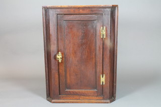 An 18th Century oak hanging corner cabinet, fitted shelves  enclosed by a panelled door 38"h x 28.5"w x 16"d