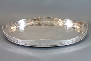 An Edwardian oval silver plated twin handled galleried tea tray  24"