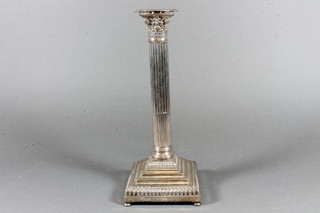 A Victorian reeded silver candlestick with Corinthian column capital on a stepped base 11", marks rubbed
