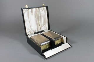 A pair of silver backed military hairbrushes with engine turned decoration Birmingham 1962, cased