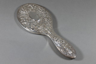 An embossed Eastern white metal silver backed hand mirror
