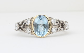 A lady's 18ct white gold dress ring set an oval cut topaz  surrounded by diamonds