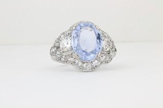 A Victorian style oval cluster dress ring set a cornflower blue sapphire surrounded by diamonds