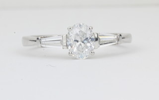 A lady's 18ct white gold dress ring set an oval diamond and with baguette cut diamonds to the shoulders, approx. 1.05ct