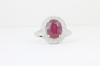 A 14ct white gold dress ring set an oval cut ruby approx 4.7ct surrounded by diamonds approx 0.75ct