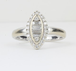 A lady's 18ct white gold marquise shaped dress ring set baguette diamonds and surrounded by diamonds