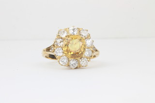 A lady's 18ct yellow gold dress ring set a circular cut yellow sapphire surrounded by diamonds