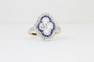 A lady's 18ct yellow gold dress ring set 4 diamonds to the centre  surrounded by sapphires and diamonds