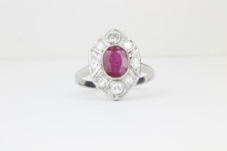 An 18ct white gold dress ring set an oval cut ruby surrounded by diamonds