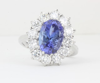An 18ct white gold dress ring set an oval cut tanzanite  surrounded by diamonds