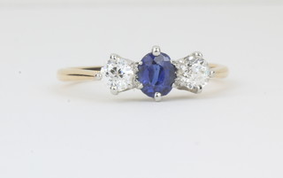 A lady's 18ct yellow gold dress ring set an oval cut sapphire supported by 2 diamonds