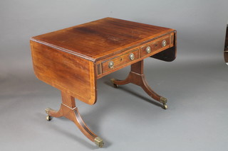 A late George III mahogany and parcel ebonised sofa table, cross  banded and boxwood line inlaid, fitted 2 short frieze drawers and  2 faux fronted opposing drawers, raised on splayed legs, brass  caps and casters 28.5"h x 56"w x 30"d