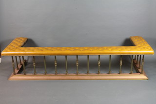 Robin Gage, a Regency style gilt brass club fender, having beige buttoned upholstered top, raised on plinth base 84"w x 18"h x  28"d