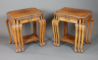 In the style of Maple & Co. an unusual pair of early 20th  Century burr walnut table nests in the early 18th Century taste  having foliate carved shaped tops, raised on bell flower and  rosette carved cabriole legs, scroll feet, the largest 24.5"h x 24"w  x 18"d   ILLUSTRATED