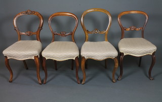 A near matching set of 4 mid Victorian walnut balloon back  dining chairs, having foliate carved spars, stuff over seats, raised  on cabriole legs