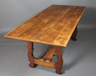 A 17th Century style oak dining table, raised on shaped trestle  ends united by an H stretcher 29"h x 72"w x 32"d