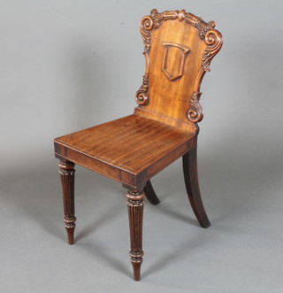 A William IV mahogany hall chair, the back centred with vacant cartouche flanked by foliate scrolls, above a solid seat raised on  lappette carved and sabre legs  ILLUSTRATED