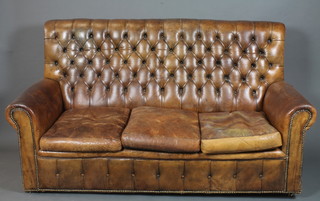 A 19th Century style brown buttoned leather club 3 seat settee, having scrolled arms raised on casters 73"w  ILLUSTRATED