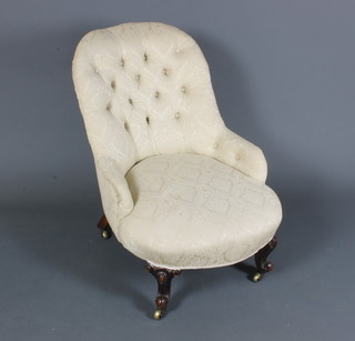 A mid Victorian mahogany framed low seat chair having cream  damask floral buttoned upholstery, raised on cabriole legs and  casters