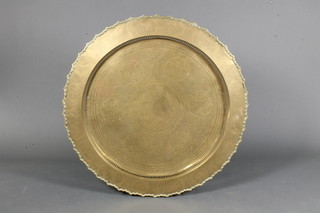 A late 19th Century Chinese brass circular tea table, centred with a roundel of script amongst foliate and dragon reserves 36" diam.