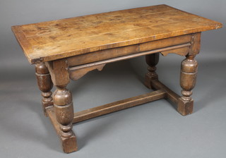 An 18th Century and later oak refectory table having a 3 plank top above a shaped apron and moulded frieze, raised on turned  supports united by an H stretcher 30"h x 55"l x 30"w